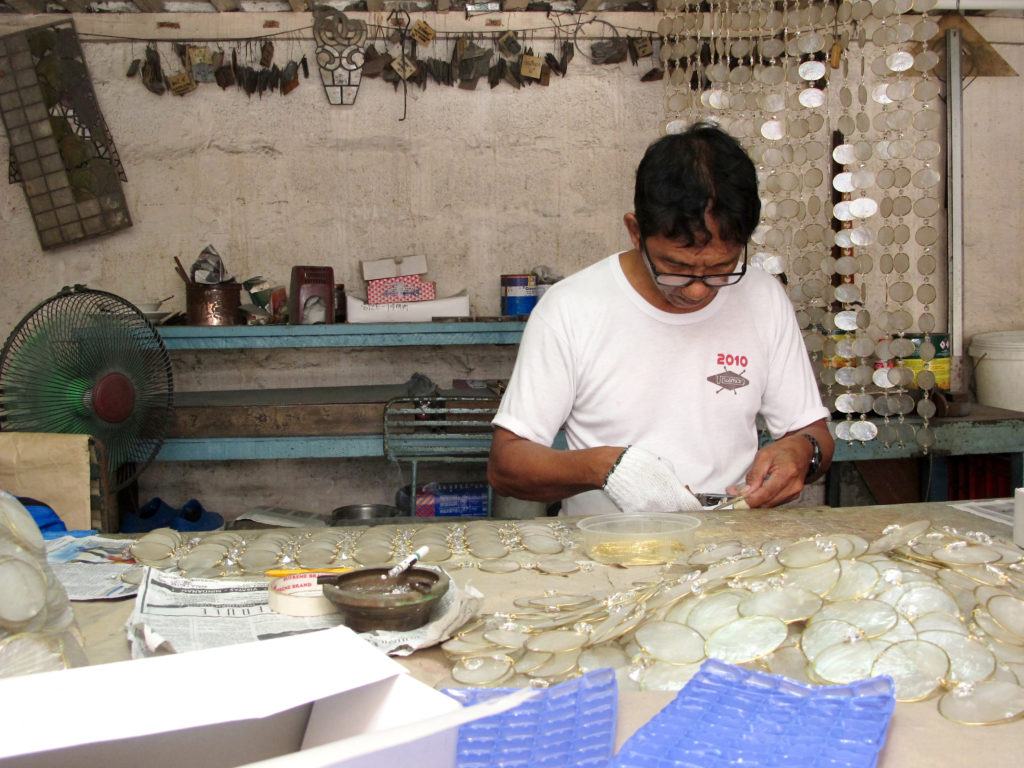 capiz shells being trimmed and edged with brass