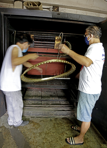 chandelier part being baked to dry sealing lacquer